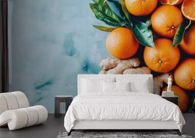 Fresh oranges and ginger root artfully arranged on blue surface Wall mural