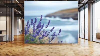 Lavender plants growing by a misty coast, with waves gently rolling in, creating a calm, moody atmosphere. Wall mural