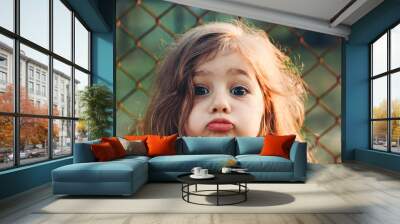 Portrait of cute little Girl with kissing lips looking at camera. Happy Kid outdoors Wall mural