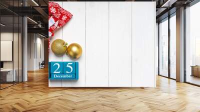 Christmas background, red gift bag and blue wooden perpetual calendar with date 25 december on white wooden background. Top view, flat lay with copy space, banner, header, New Year concept Wall mural