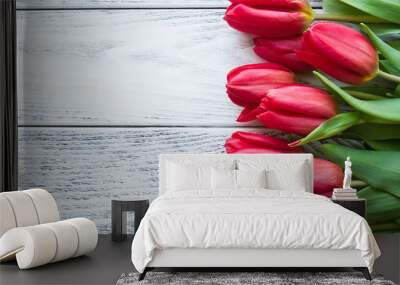 Spring bouquet of red tulips on the wooden table top view Wall mural