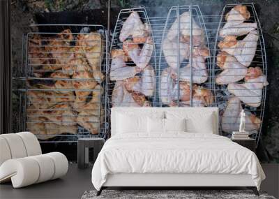 Barbecue grill chicken meat. Tasty chicken legs and wings on the grill with fire flames.  Wall mural