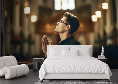 Young man praying to god in church. Faith in religion and belief in God. Power of hope or love and devotion. Wall mural