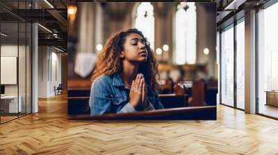 Young woman praying to god in church. Faith in religion and belief in God. Power of hope or love and devotion. Wall mural