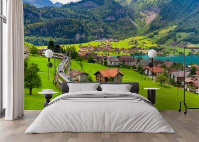 Famous electric red tourist panoramic train in swiss village Lungern, canton of Obwalden, Switzerland Wall mural