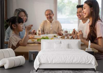 Asian big happy family eat foods on dinner table together in house. Wall mural