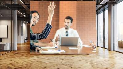 Asian office woman raising hand for asking question manager in meeting Wall mural