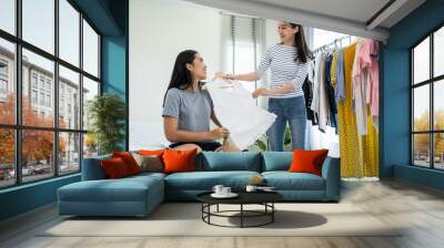 Asian young amputee leg woman and friend choosing clothes on closet rack.  Wall mural