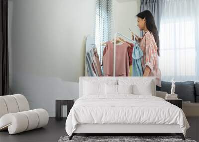 Asian young beautiful woman preparing clothes and packing a suitcase.  Wall mural