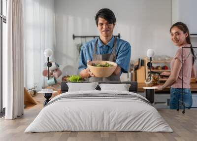 Asian young male amputee without arm cooking foods in kitchen at home.  Wall mural