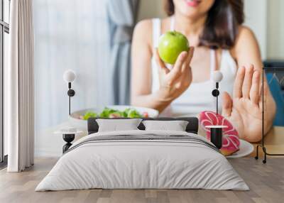 Asian young woman refuse junk food while choose to eat healthy salad and fruit for her healthy. Girl take care of herself by having high nutrition food every day. Good food for healthy Dieting concept Wall mural