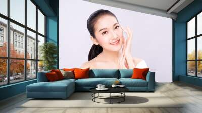 Beautiful Young Asian woman with clean fresh white skin touching her own face softly in beauty pose. Girl touching with fingers in white background. Facial treatment, cosmetology, spa, make up concept Wall mural