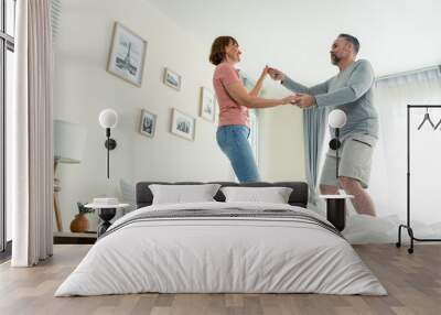 Caucasian senior couple dancing with music together in bedroom at home.  Wall mural