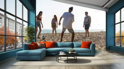 Group of Asian young man and woman play soccer on the beach together.  Wall mural