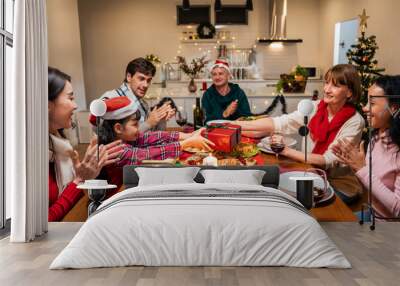 Multi-ethnic family exchanging presents during Christmas party at home Wall mural