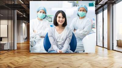 Portrait of Caucasian girl patient smiling, sitting with dental team. Wall mural