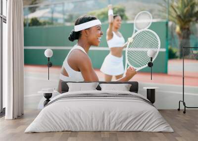 Stay fierce and fight for what you want. Shot of two sporty young women cheering while playing tennis on a court. Wall mural