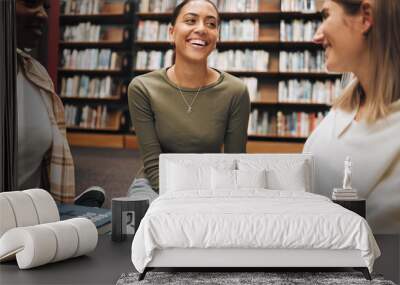 Student, friends and book discussion in library with smile for education, learning or knowledge at university. Group of happy women enjoy conversation, book club or social study for research project Wall mural