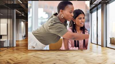 A little bit of support can go a long way. Shot of a two businesswomen discussing something on a computer. Wall mural