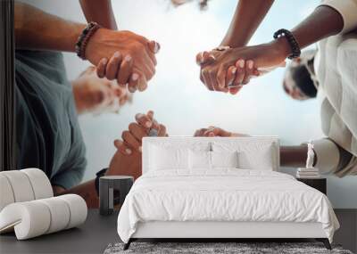 Holding hands, support and friends praying for spiritual growth, community and gratitude together with sky from below. Group of people in partnership for hope, love and human faith in connection Wall mural