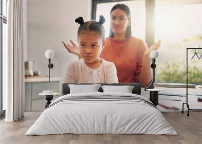 Upset, discipline and family while offended and stubborn little girl looking unhappy with her scolding mother in the background. Naughty, problem and bad child angry and ignoring her parent at home Wall mural