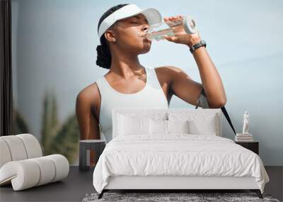 Tennis, drinking water and black woman on court, sports and fitness with nutrition, wellness and workout. African person, outdoor and athlete with bottle racket and training with break and healthy Wall mural