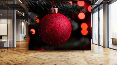 Sparkling red christmas ornament adorning a tree with glowing red lights in the background Wall mural