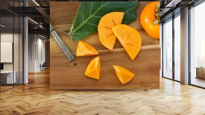 Macro of persimmon fruit on wooden board Wall mural