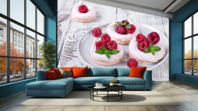 Mini Pavlova cakes topped with raspberries and mint on white wooden table Wall mural