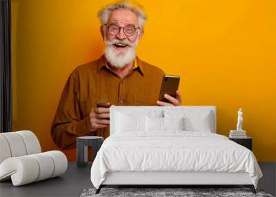 Full size body length excited confident smiling elderly gray-haired bearded man 50s years old wears brown shirt hold in hand use mobile cell phone isolated on plain yellow background studio portrait Wall mural