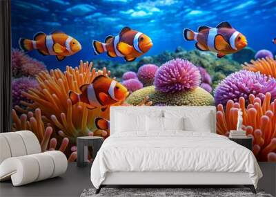 Vibrant coral reef scene featuring playful clownfish swimming among colorful anemones in clear blue water. Wall mural