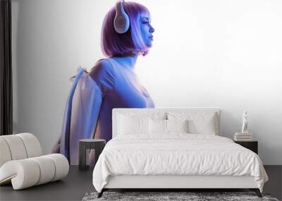 Beautiful woman with purple hair in futuristic costume over white background. Blue and violet neon light. Portrait of young girl in modern headphones listening music. Free space for text. Wall mural