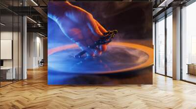 Hand with a mysterious key in a bowl of magic liquid. Colored smoke moves beautifully against on a dark background. Fortune teller, mind power, prediction, halloween concept. Secret knowledge. Wall mural