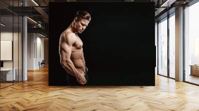 Muscular model young man on dark background. Fashion portrait of strong brutal guy with trendy hairstyle. Sexy naked torso, six pack abs. Male flexing his muscles. Sport workout bodybuilding concept. Wall mural