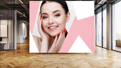 Portrait of model with natural nude make up. Beautiful young woman with perfect glow clean skin looking into the hole of pink paper. Free space for text. Wall mural