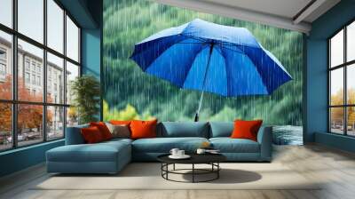 Blue umbrella shielding against heavy rain in a lush natural landscape, embodying the essence of rainy weather and resilience. Wall mural