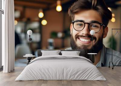 Cheerful young man with beard and glasses in relaxed office environment, close-up portrait Wall mural