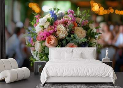 Elegantly arranged wedding bouquet in focus with a soft background of a couple and guests celebrating love Wall mural