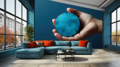 Illuminated Hand Cradling a Circular Form Against a Deep Blue Backdrop in an Abstract Composition Wall mural