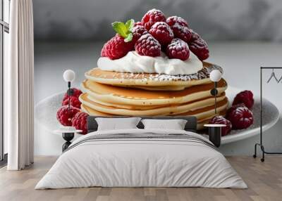 Indulgent fluffy pancakes adorned with fresh raspberries, creamy whipped topping, and a dusting of powdered sugar on a pristine white plate Wall mural