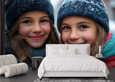 Joyful winter portrait of two smiling girls outdoors in a snowy landscape Wall mural