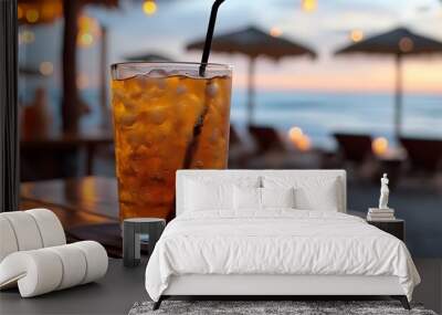 Refreshing iced tea served on a table at a beach bar with ocean views and sandy surroundings Wall mural