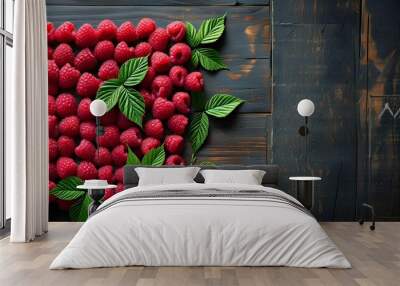 Rustic display of ripe raspberries adorned with fresh leaves on a dark wooden surface, perfect for culinary backgrounds and elegant food photography Wall mural