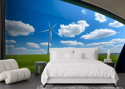 Scenic view of modern windmills on a grassy field against a clear blue sky through a car window Wall mural