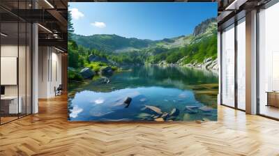 Serene mountain lake embraced by vibrant forest and rugged landscape beneath a radiant blue sky, an ideal haven for nature lovers and hiking enthusiasts. Wall mural