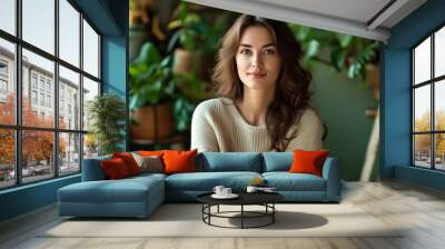 Stylish home portrait of a beautiful woman surrounded by vibrant greenery and cozy decorations in a serene living space Wall mural