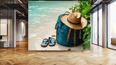 Tropical paradise with backpack, hat, and flip flops on sandy beach overlooking turquoise water and lush green foliage Wall mural