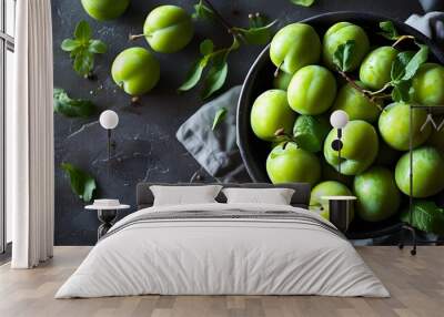 Vibrant overhead display of ripe organic green plums in a dark bowl, showcasing a Mediterranean culinary favorite Wall mural