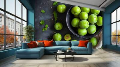 Vibrant overhead display of ripe organic green plums in a dark bowl, showcasing a Mediterranean culinary favorite Wall mural