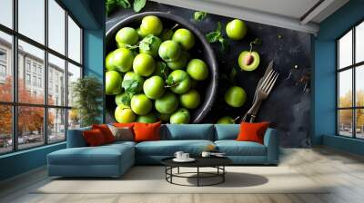 Vibrant overhead display of ripe organic green plums in a dark bowl, showcasing a Mediterranean culinary favorite Wall mural